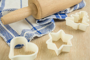 image of rolling pin, towel, and blue holiday cookie cutters